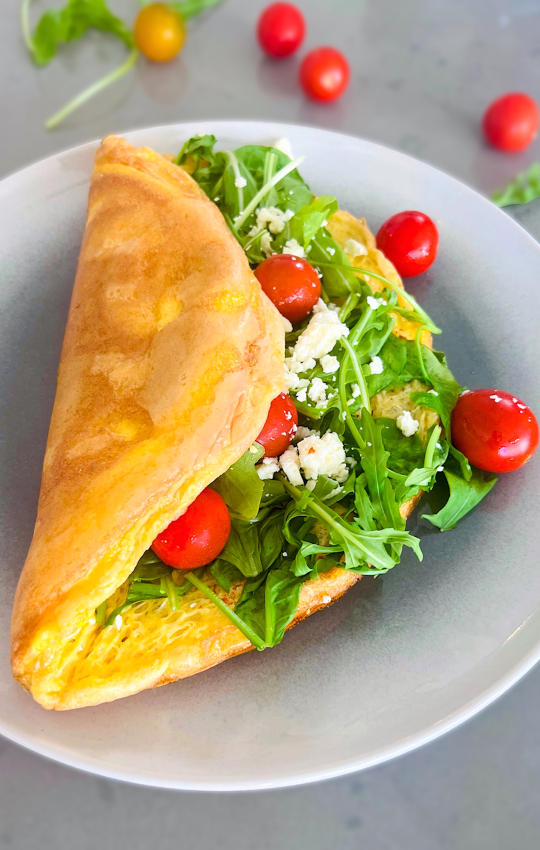 Step-by-step preparation of golden fluffy omelette with spinach, arugula, and feta