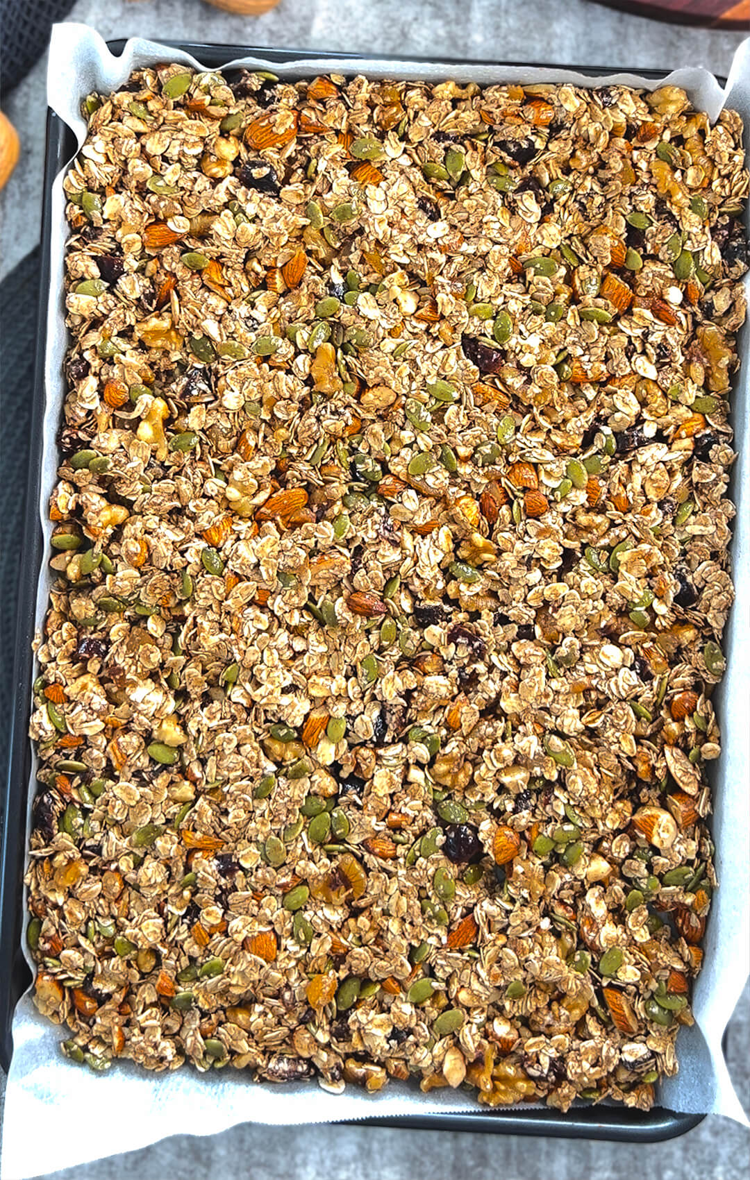 Healthy granola cluster mix ready to bake on a parchment-lined tray