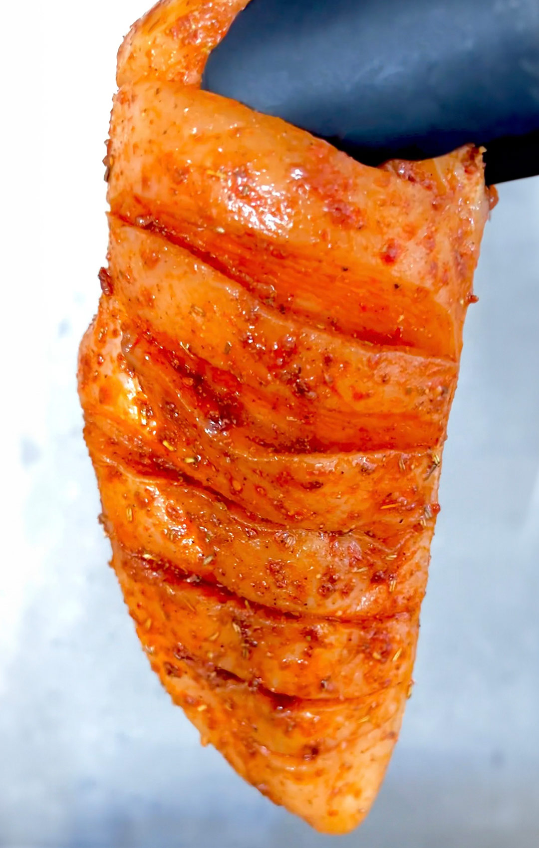 Chicken breast with visible angled slits marinated in herbs and oil Image Name: marinated-angled-slits-chicken 