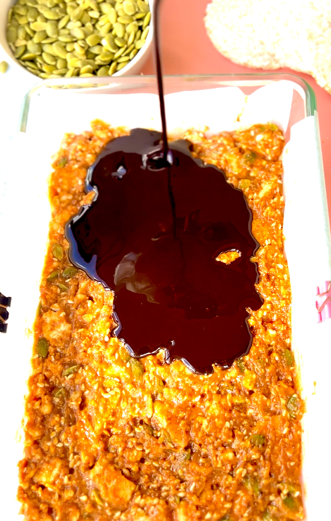Chocolate being drizzled over the rice cake bar mixture before chilling- quick and easy to make
