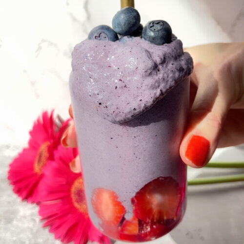 Spoon dipped into thick and creamy blueberry and strawberry chia smoothie showing its rich texture