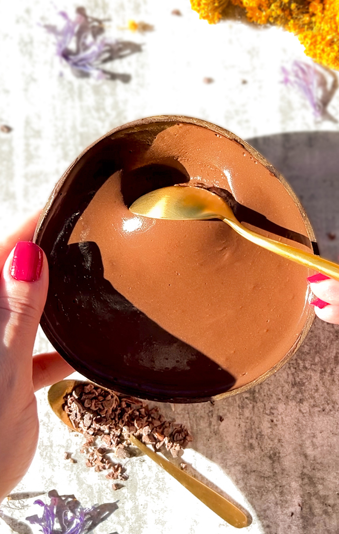 Thick and creamy chocolate cottage cheese mousse served in a coconut shell bowl, showing its silky, shiny texture and smooth and thick consistency.