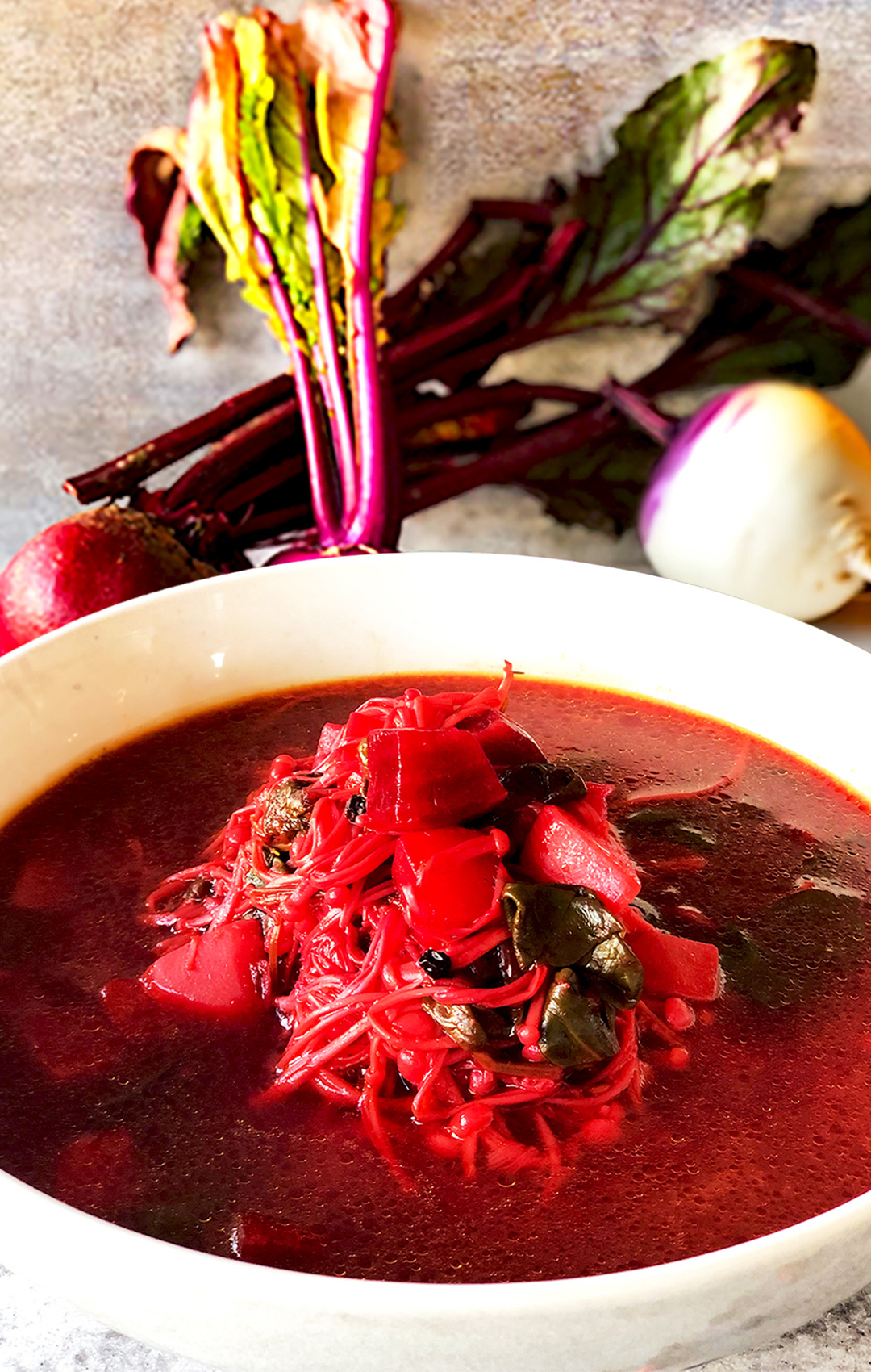 Bowl of vibrant beetroot, turnip, and enoki mushroom soup for weight management and cold days; vegan, paleo, and gluten-free