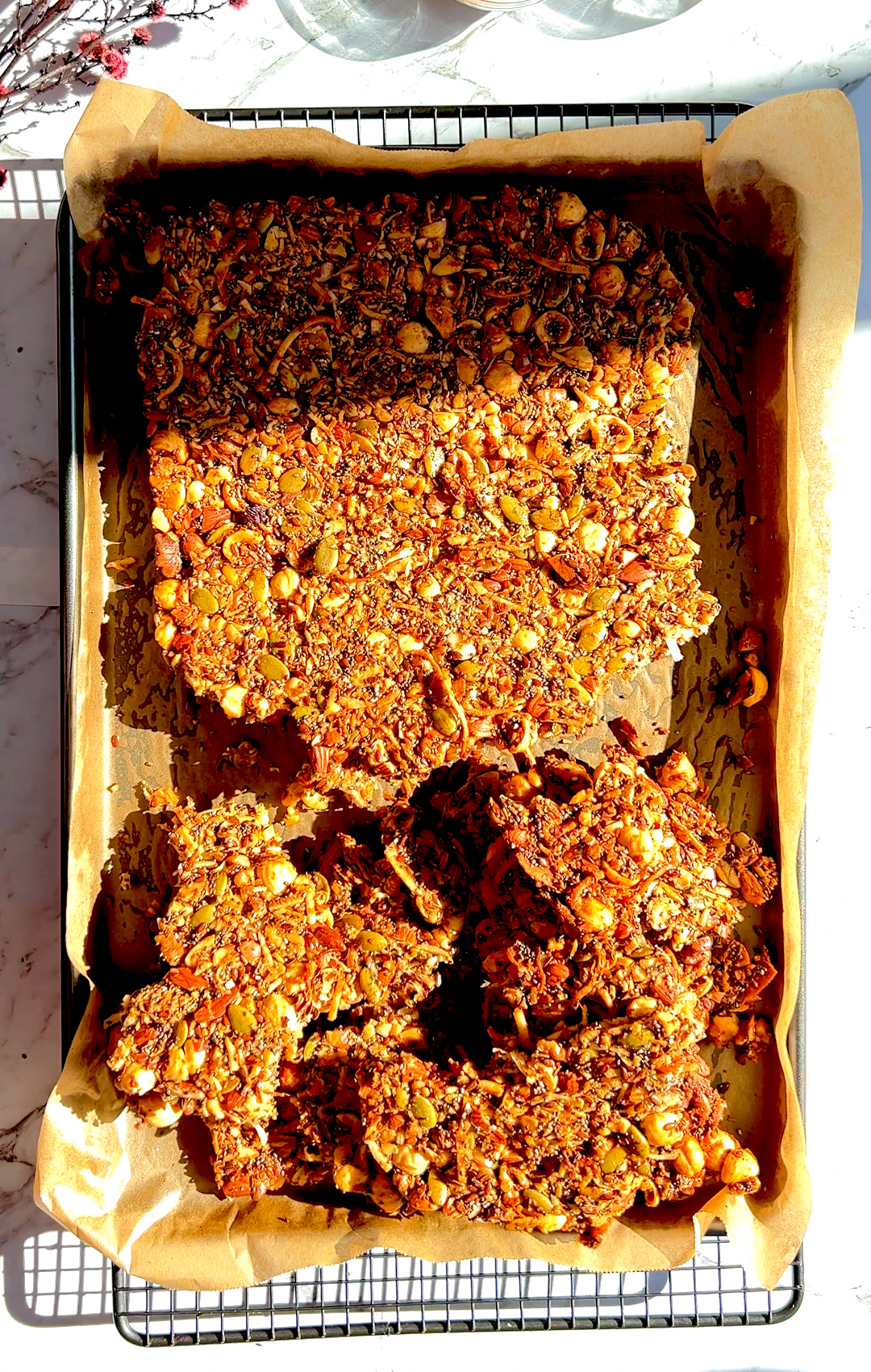 Cutting baked Nutty Coconut Crunch Granola into big crunchy clusters. Made with egg white, seeds, and healthy fats for energy and protein.