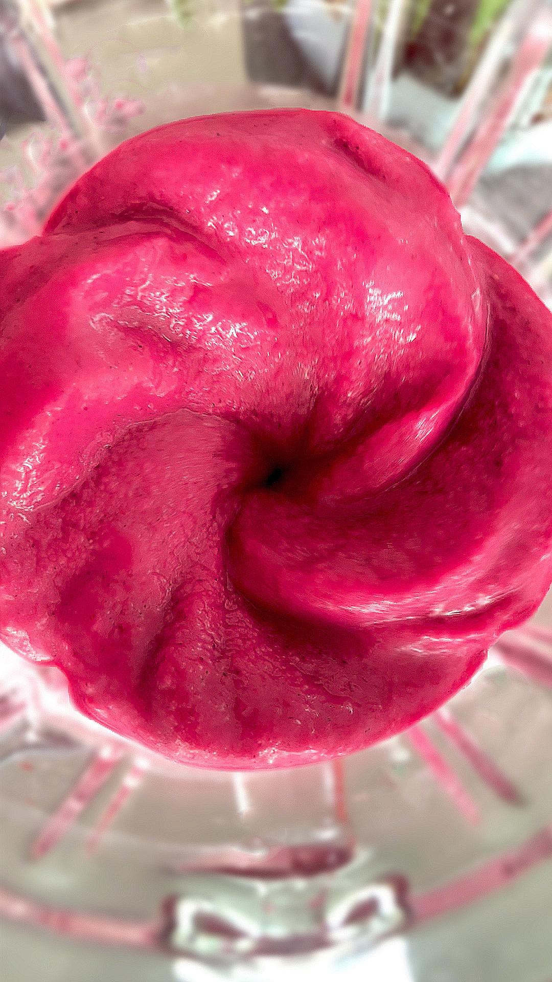 Tropical mango dragon fruit blackberries smoothie swirling in a blender showing its thick, creamy texture and vibrant pink colour.