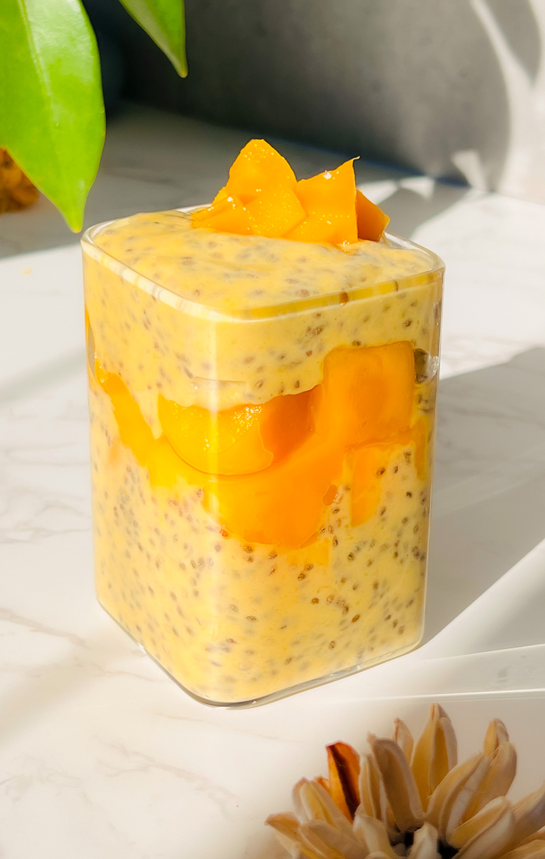 Creamy mango chia pudding layered with chopped mango in a glass jar, perfect for a healthy breakfast, Dairy-Free or tropical dessert