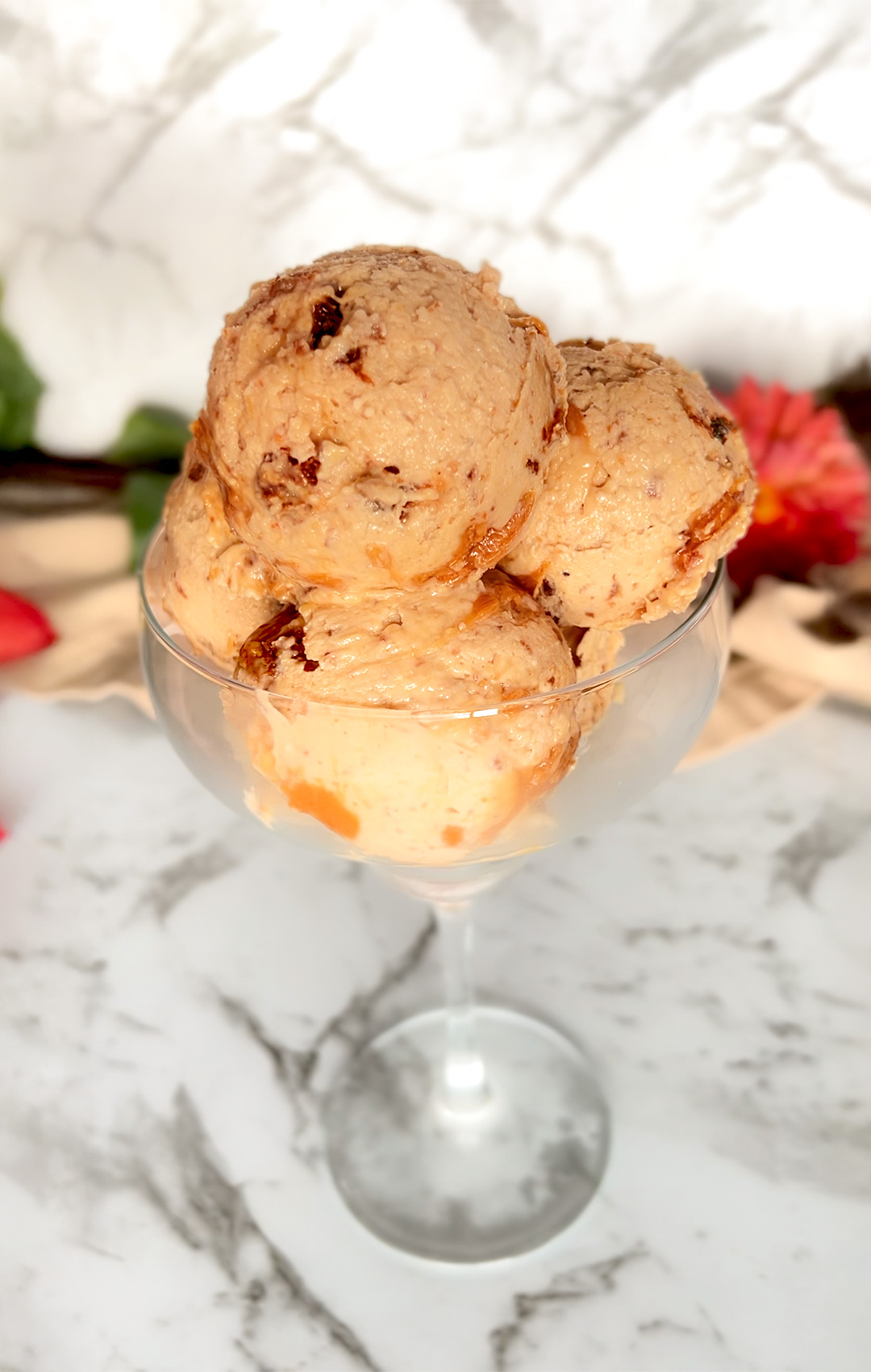Side view of ricotta peanut butter ice cream in a glass, showing creamy texture and swirl detail