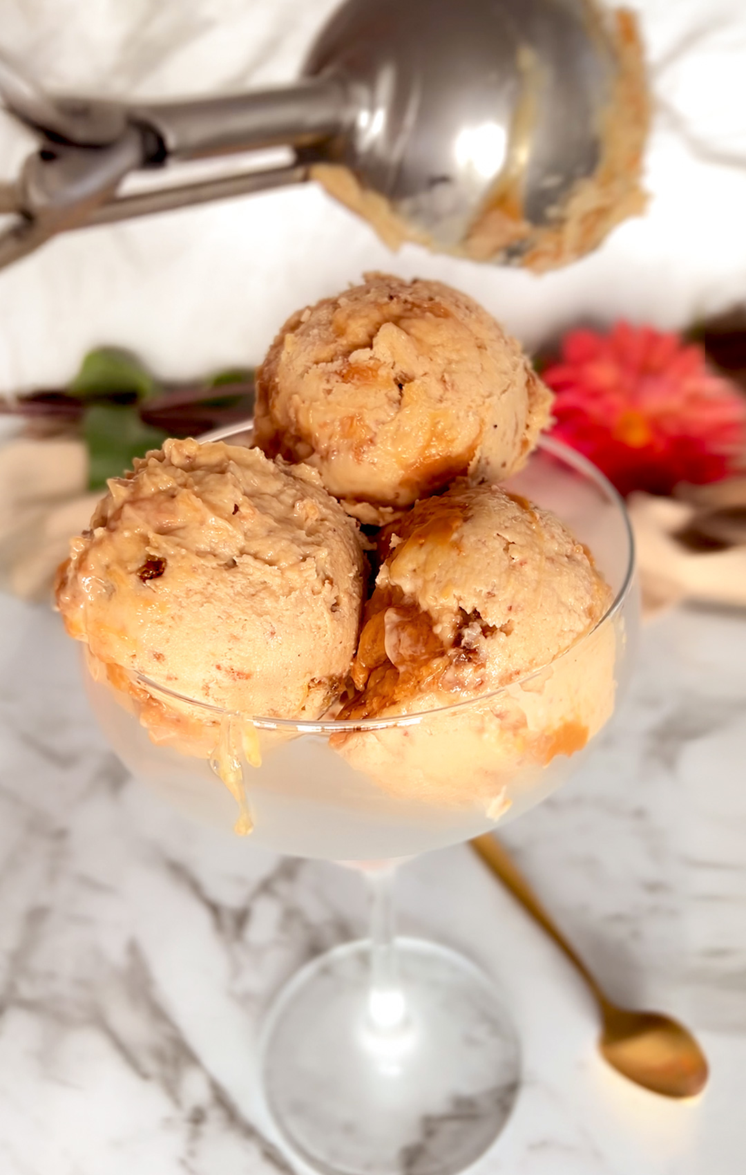 Glass filled with no-churn ricotta peanut butter ice cream, topped with a visible honey peanut butter swirl