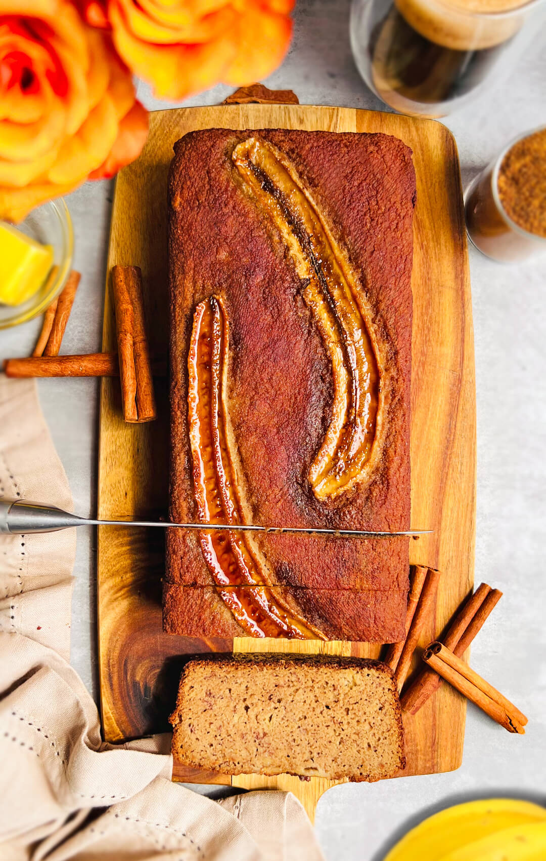 Slicing Perfect Paleo Banana Bread on a board, highlighting the fluffy , moist texture of this healthy gluten-free, Refined Sugar-Free , dairy-free banana bread