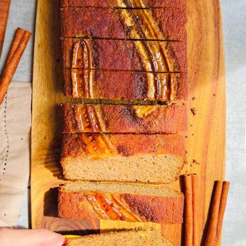 Picking up a slice of Perfect Paleo Banana Bread to show the soft, moist texture. A healthy banana bread made with almond flour, coconut flour, and coconut sugar that is gluten-free, dairy-free, and naturally sweet.