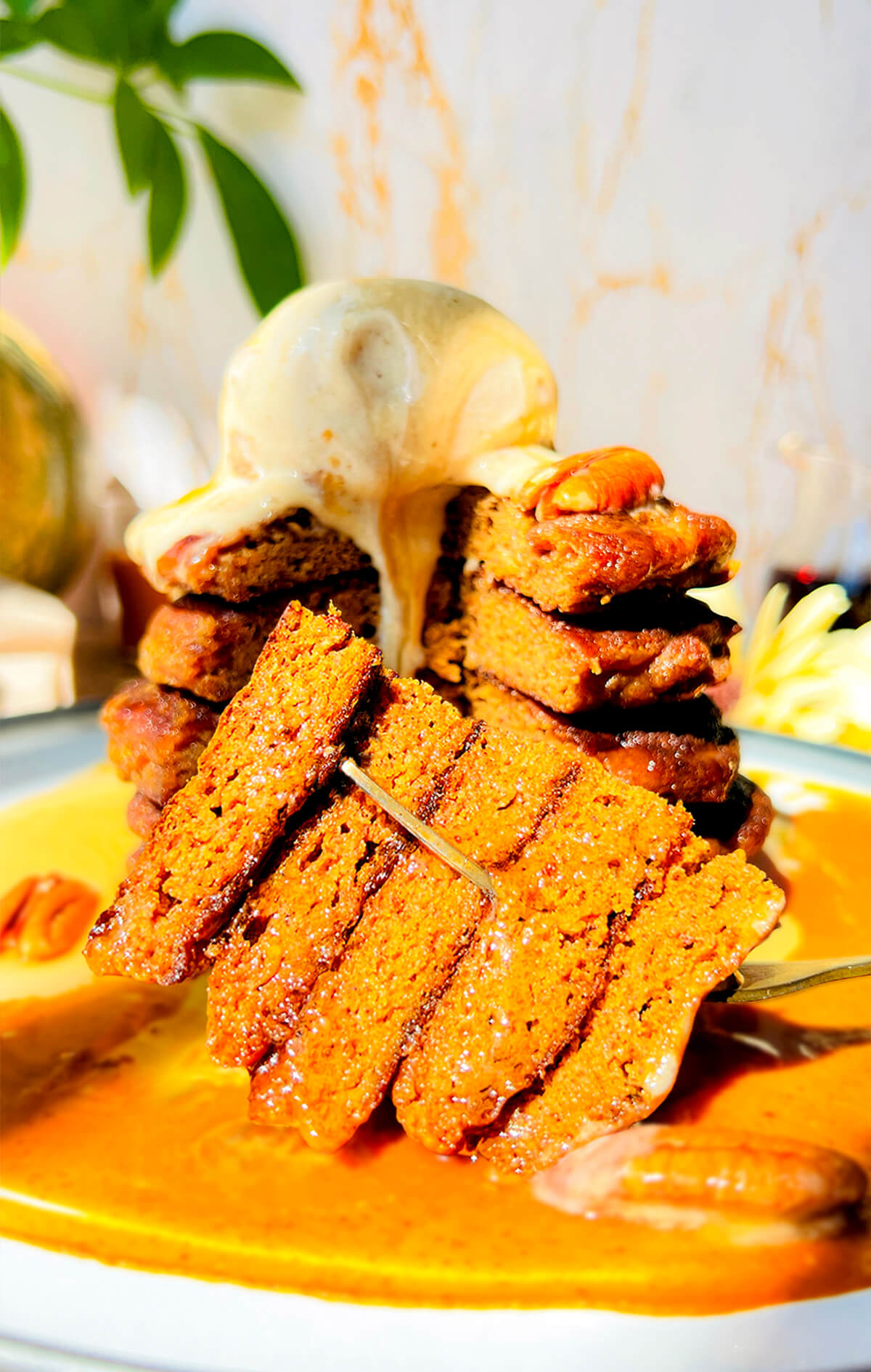 Close-up of a fluffy pumpkin pancake slice on a plate, showing its soft, moist, pillow-like texture. These healthy keto pancakes are made with almond flour, coconut flour, lupin flour, almond butter, and monk fruit sweetener, making them sugar-free, gluten-free, dairy-free, and high in protein.