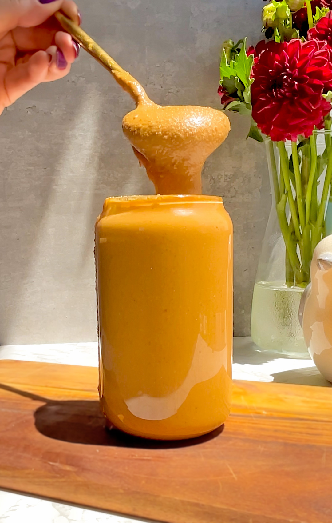 Spoon dipped into Best Homemade Roasted Peanut Butter, thick and creamy with golden roasted peanuts, naturally nutty taste, no oils, no preservatives, no sugar.simple one-ingredient recipe