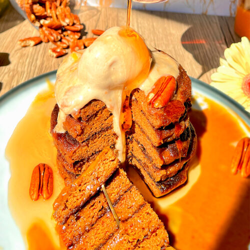 Fluffy stack of keto pumpkin pancakes topped with a scoop of sugar-free vanilla ice cream and pecans, drizzled with sugar-free maple syrup and served with creamy pumpkin almond butter sauce on the side. Made with almond flour, lupin flour, and coconut flour for a healthy, high-protein, gluten-free, dairy-free breakfast.