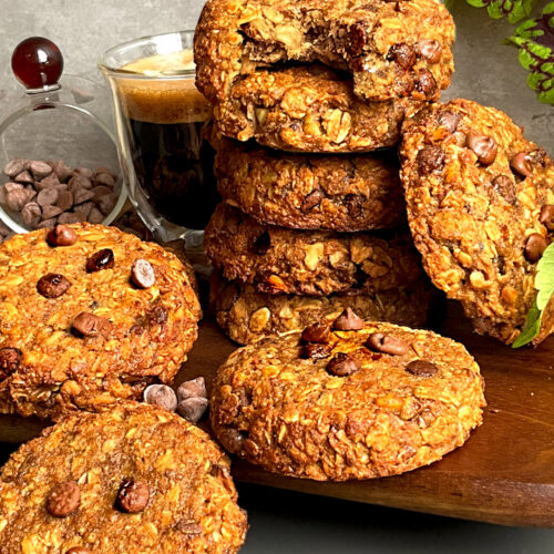 Stack of chewy banana tahini oatmeal cookies with walnuts and chocolate chips, a quick and easy 15 minute healthier cookie option served with coffee
