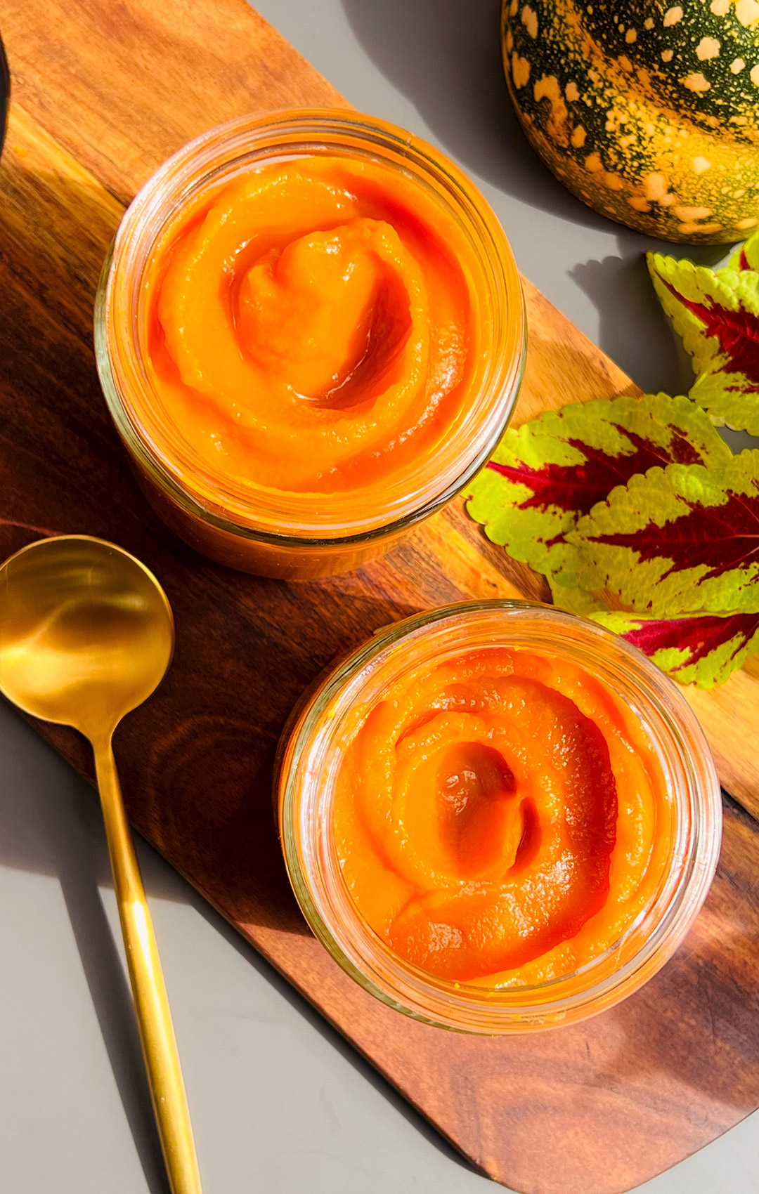 How to Make Pumpkin Purée 2 Ways in glass jars, silky and creamy texture. Healthy, no water, perfect for pies and desserts. Close up of homemade pumpkin purée in glass jars showing silky smooth, thick and creamy texture. Freshly baked or cooked pumpkin purée made without water.