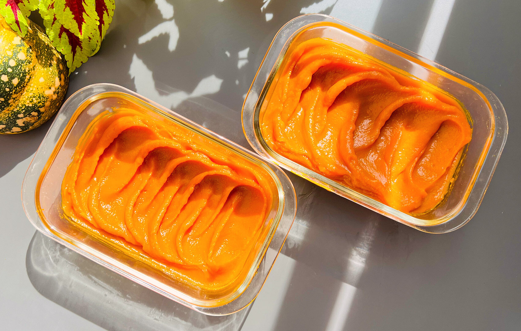 Close up of homemade pumpkin purée in glass container showing silky smooth, creamy texture. Freshly baked or cooked pumpkin purée made without water. Quick and easy, Healthy, refined sugar free, vegan, paleo, gluten free, and perfect for pies, cheesecakes, pancakes, and fall desserts.”