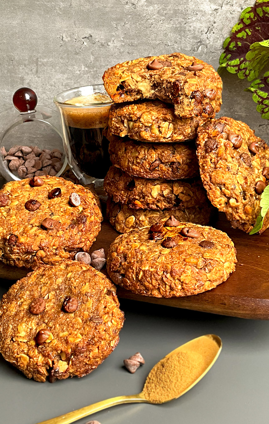 Stack of chewy banana tahini oatmeal cookies with walnuts and chocolate chips, a quick and easy 15 minute healthier cookie option served with coffee- Gluten-free-sugar-free