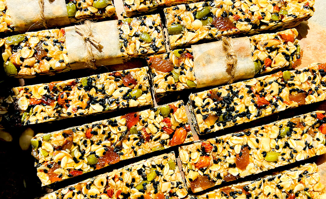 sliced oat and nut granola bars with honey and tahini on a wooden board, chewy gluten free and naturally sweetened, shining in sunlight and perfect for breakfast, snacks or meal prep also perfect for pre and post workout