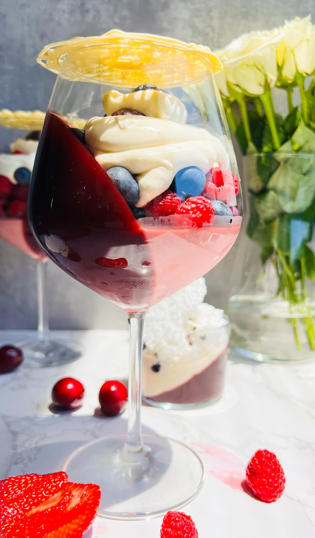 A close-up of the layered textures in this healthy pomegranate berry trifle. The creamy flummery melts into the fresh berries, topped with light whipped cream and finished with a white chocolate lace that cracks before serving. Naturally gluten free, no refined sugar, and easy to make ahead for entertaining.