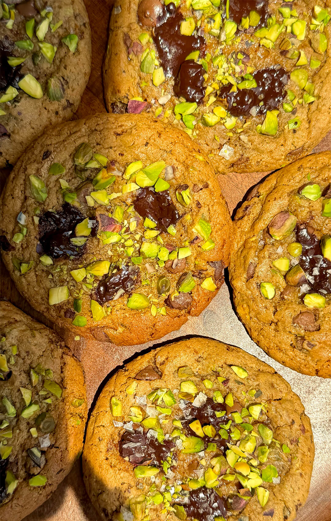Finished bakery-style pistachio chocolate chunk cookies with caramelised crispy edges, soft chewy centres, melty dark chocolate and chopped pistachios. Healthy gluten-free and no refined sugar cookies.