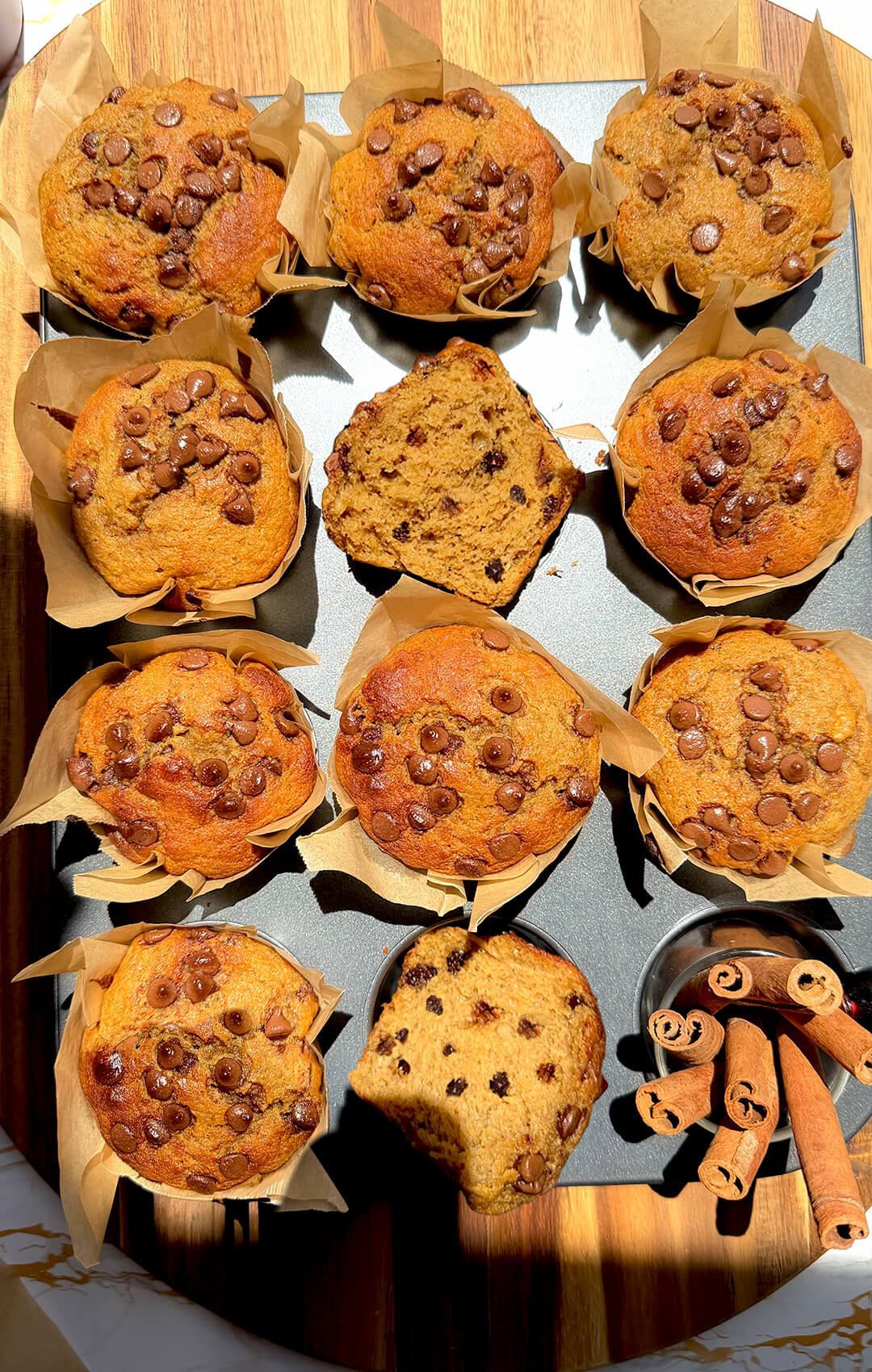 Platter of Banana Oat Chocolate Chip Muffins with cut pieces showing soft crumb, quick and easy high protein high fiber muffins made with oat flour and lupin flour