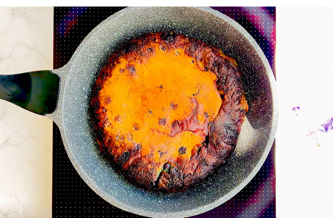 Cooked fluffy blueberry omelet in skillet, golden caramelised blueberry edge and puffy centre, ready in less than 10 minutes. flourless, keto, gluten-free, low-carb, sugar-free, healthy breakfast or brunch. perfect for weekend