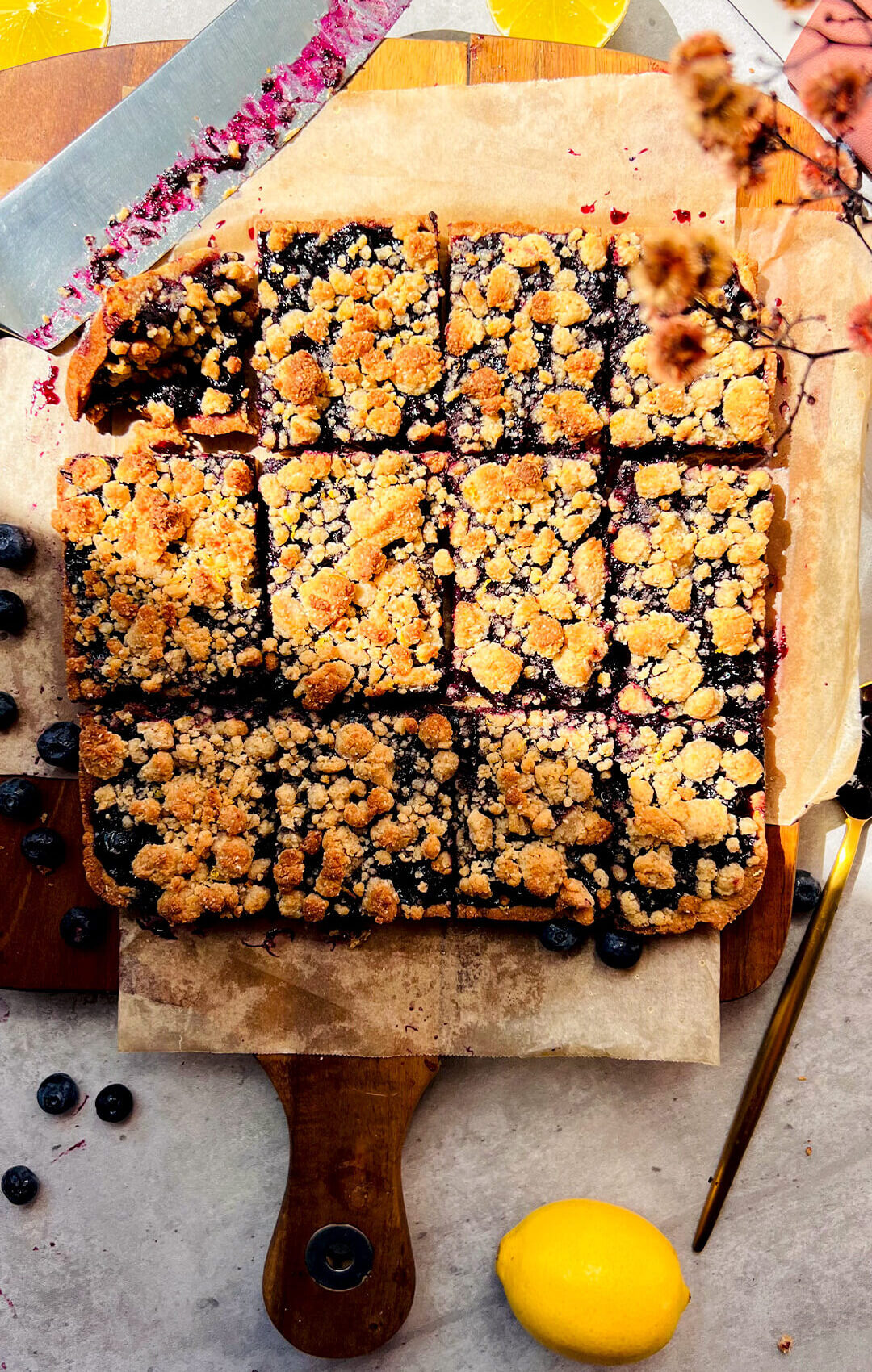Healthy blueberry crumble bars cut into neat squares, showing a thick sweet and tangy blueberry sauce filling with whole berries and a soft buttery base topped with golden crumble, made with almond flour, coconut flour and coconut oil, lemon zest, gluten-free, dairy-free, paleo friendly, refined sugar-free, perfect for meal prep.