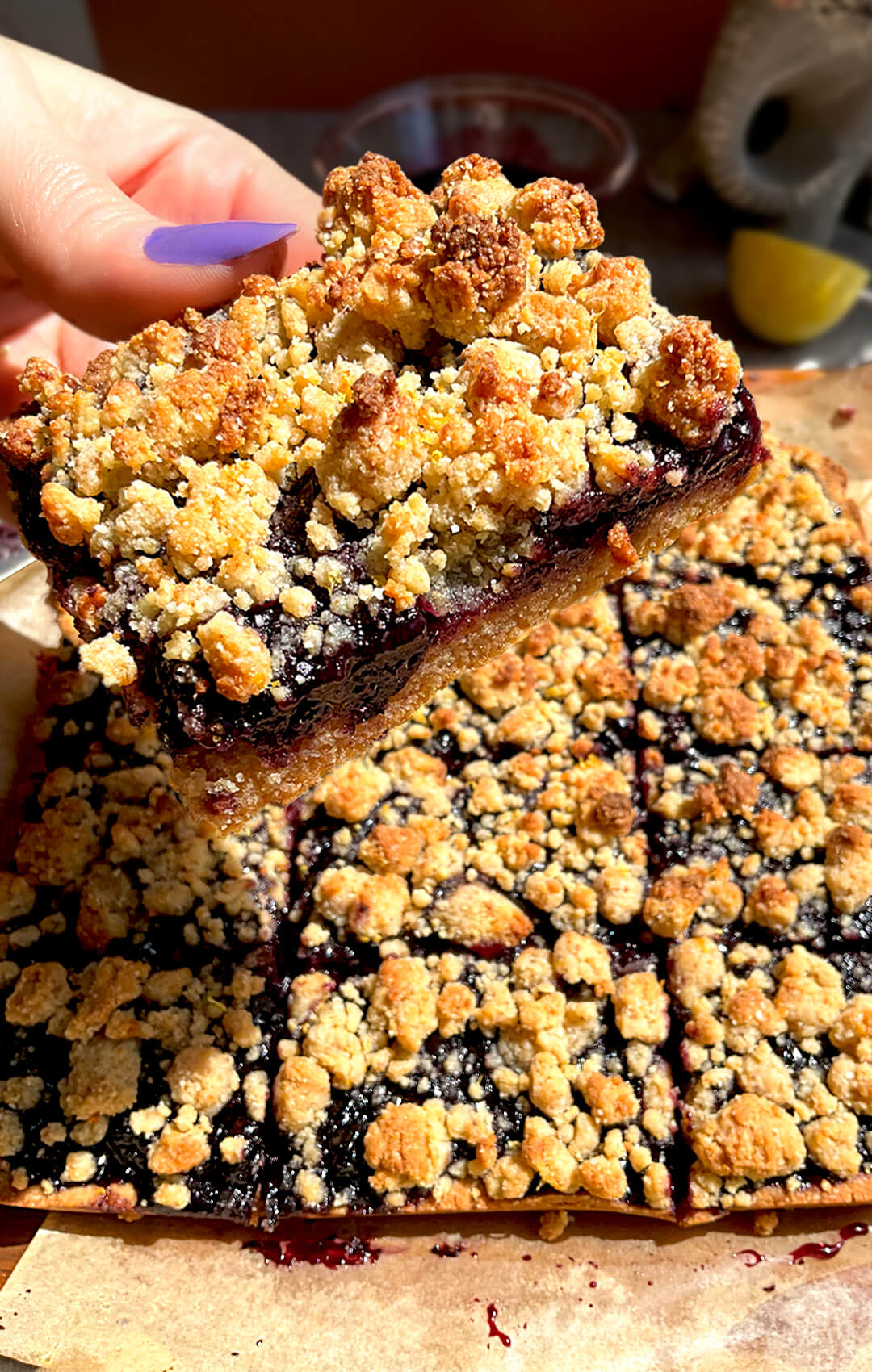 Close up of healthy blueberry crumble bars buttery golden crumble top with a thick, glossy, sweet and tangy blueberry sauce filling that stays jammy, layered on a soft buttery almond flour base, gluten-free, grain-free, dairy-free, paleo friendly and refined sugar-free