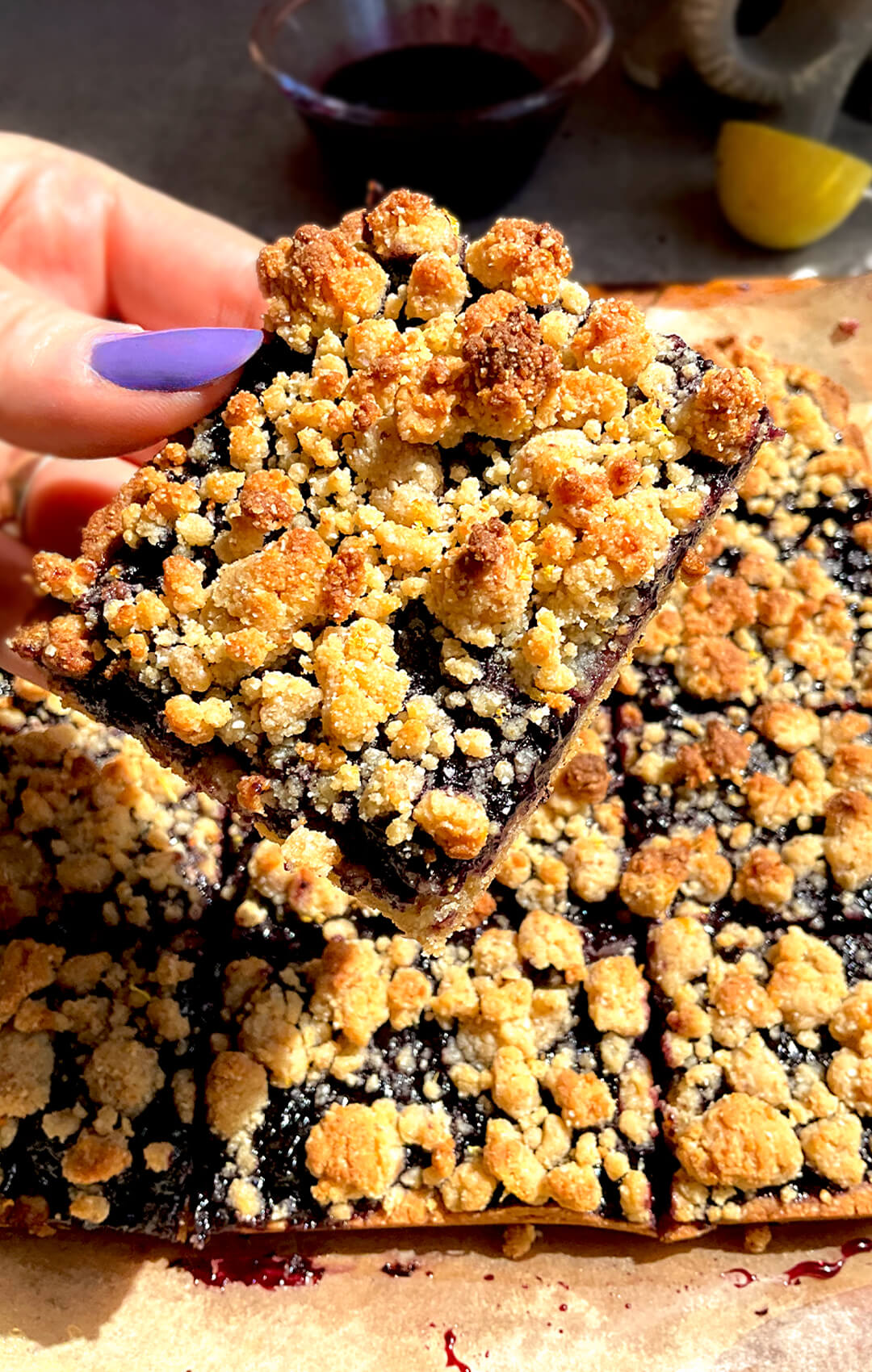 Close up of healthy blueberry crumble bars buttery golden crumble top with a thick, glossy, sweet and tangy blueberry sauce filling that stays jammy, layered on a soft buttery almond flour base, gluten-free, grain-free, dairy-free, paleo friendly and refined sugar-free