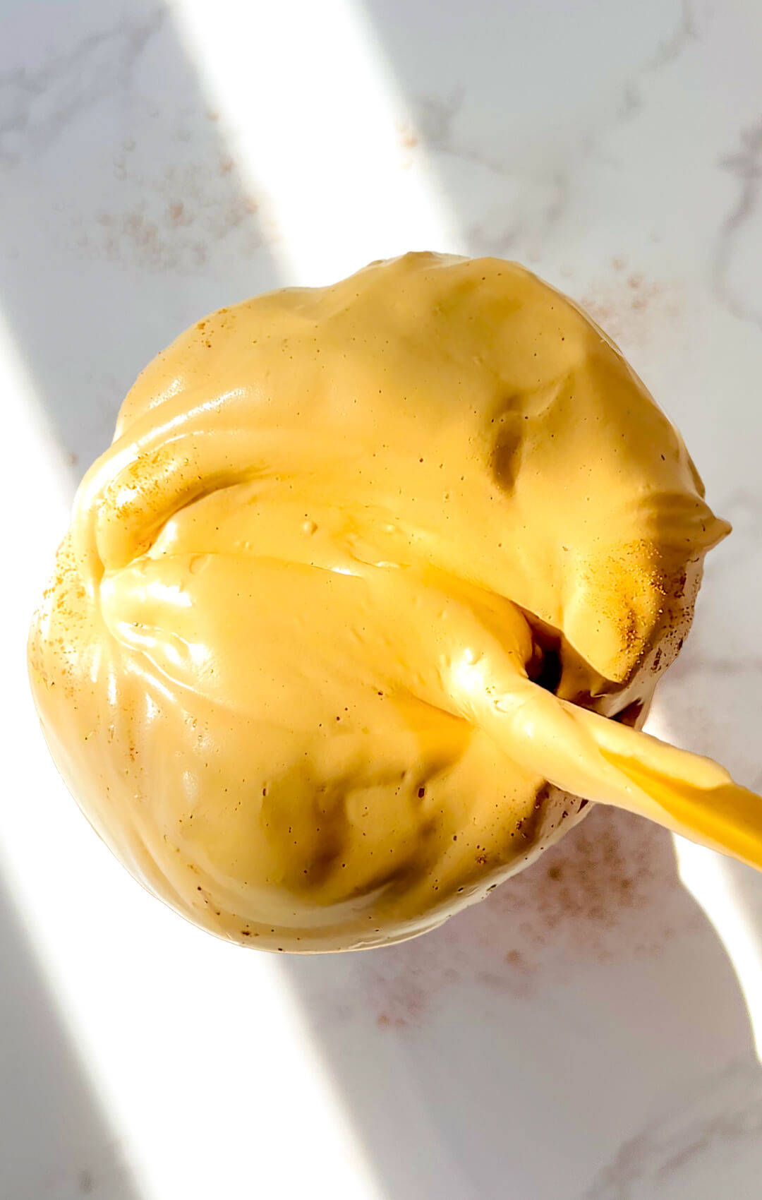 Top view of Honey Dalgona Coffee Chia Pudding with thick glossy whipped honey coffee spread all around and fully covering the creamy chia pudding, showing a smooth velvety stable texture that holds its shape beautifully, a healthy morning coffee and creamy breakfast treat that is quick and easy to make in 5 minutes, naturally sweetened, paleo, gluten-free, dairy-free, and refined sugar-free.