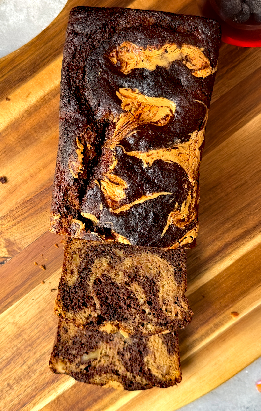 Freshly baked healthy marble banana bread loaf sliced to reveal a tender, moist crumb with chocolate marbling and peanut butter swirl, soft texture with walnut crunch, gluten-free and naturally sweetened.