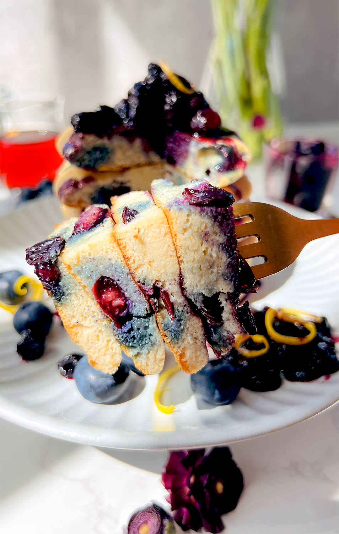 Close-up of the inside of fluffy paleo blueberry pancakes on a fork, showing a soft, tender, pillowy crumb, juicy blueberries, naturally light sweetness, and a healthy gluten-free dairy-free grain-free texture. perfect coconut flour pancake for weekend breakfast or brunch.