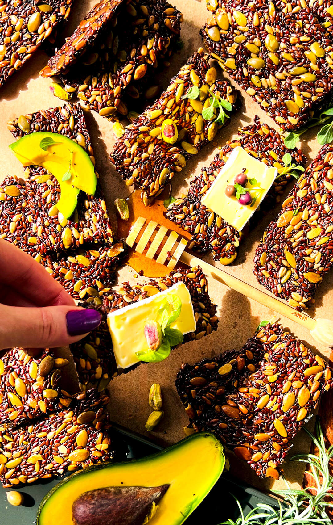 Gluten-free seed crackers topped with cheese, honey, basil and pistachio, thin crunchy homemade crackers perfect for healthy snacking and grazing boards