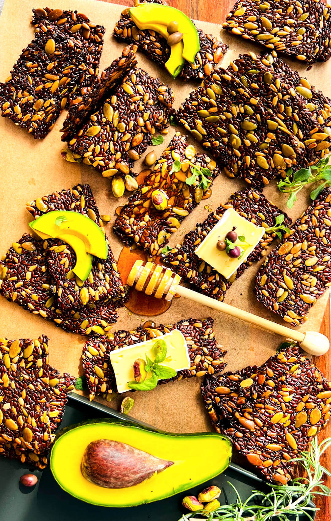 Crispy Keto seed crackers, are, thin and crunchy served with avocado, cheese, honey, rosemary and basil, crispy low-carb homemade crackers made with nutritious seeds