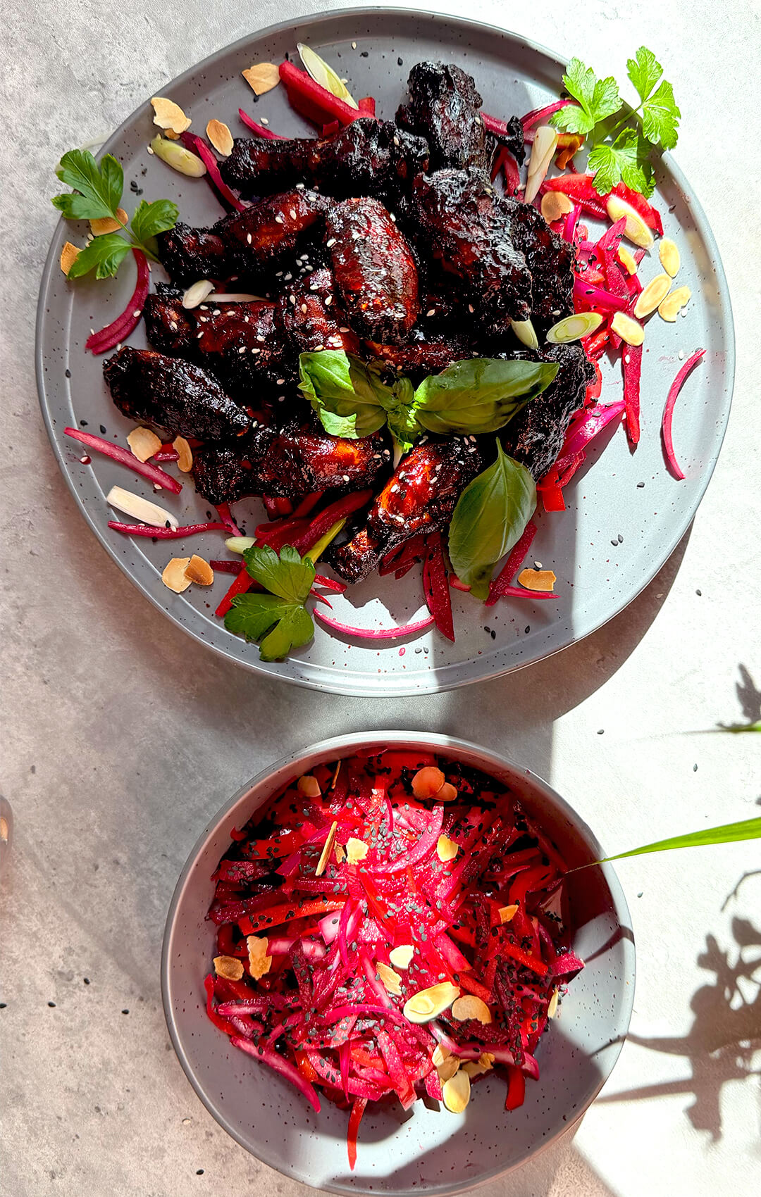 Glossy crispy sticky honey soy chicken wings with a dark caramelised glaze, sesame seeds, fresh basil, parsley, pink salad, and toasted almonds. These air fryer wings are healthy, dairy-free, high-protein, naturally sweetened with honey, smoky, sweet, savoury, slightly spicy, crispy on the edges, tender inside, and easy to make at home.