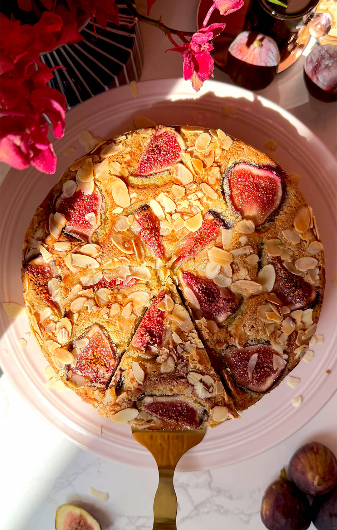 Top view of Fig Almond Olive Oil Cake with one slice cut out, showing the golden fig and almond topping with a soft almond flour crumb inside. This healthy sugar-free, gluten-free and dairy-free cake is made with wholesome ingredients and looks perfect for afternoon tea or dessert.