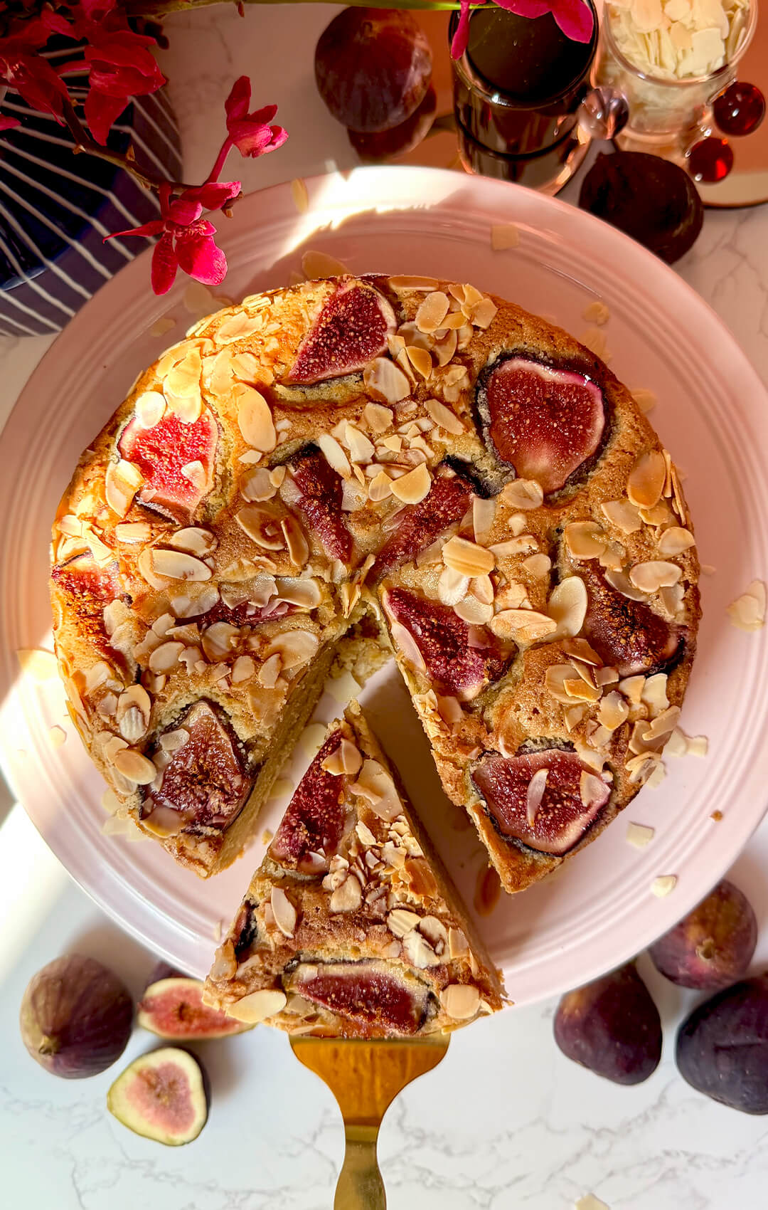 Top view of Fig Almond Olive Oil Cake with one slice cut out, showing the golden fig and almond topping with a soft almond flour crumb inside. This healthy sugar-free, gluten-free and dairy-free cake is made with wholesome ingredients and looks perfect for afternoon tea or dessert.