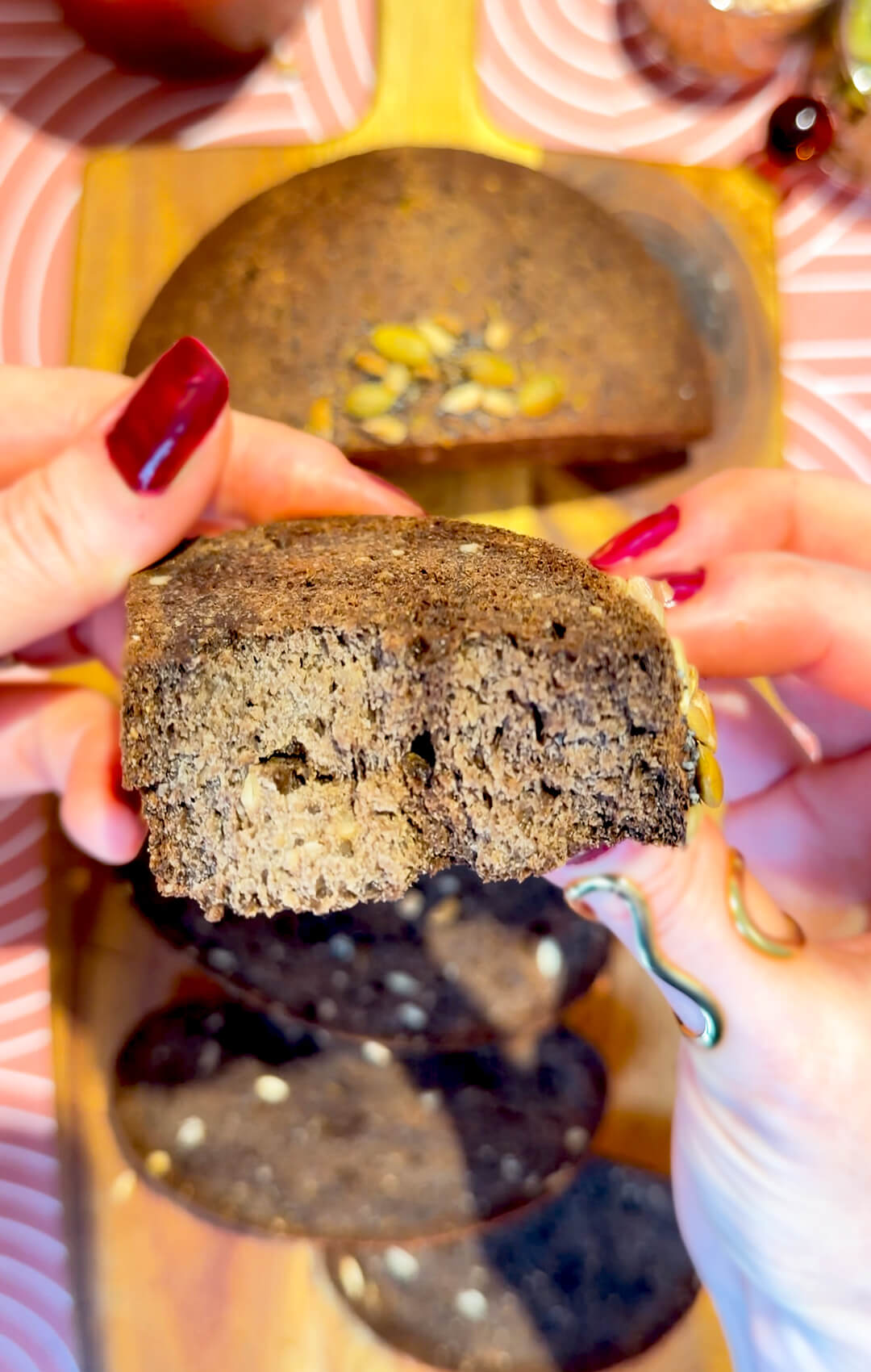 Rustic brown lentil bread slice held by hand to show the soft, chewy, flexible crumb and small air pockets. This gluten-free, flourless bread is yeast-free, egg-free, high in fibre, protein-rich, easy to make at home, and has a delicious dark rye-style bread flavour without tasting like lentils.