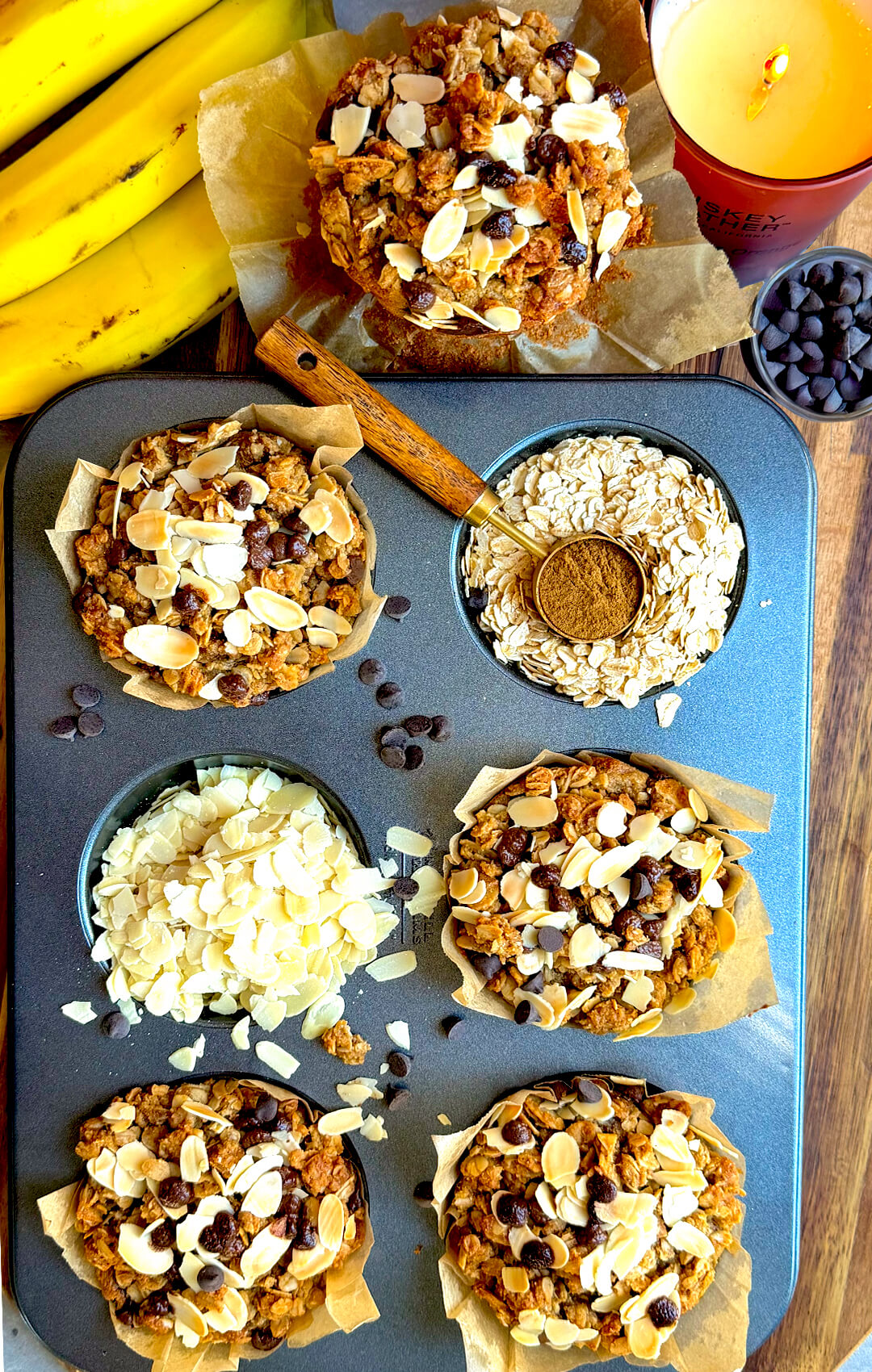 Gluten-free banana bread crumble muffins in a muffin tray with ripe bananas, rolled oats, coconut sugar, sliced almonds, and sugar-free chocolate chips. These soft, delicious, bakery-style banana muffins are dairy-free, refined sugar-free, naturally sweetened, satisfying, and quick and easy to make at home for a healthy breakfast, snack, or meal prep.