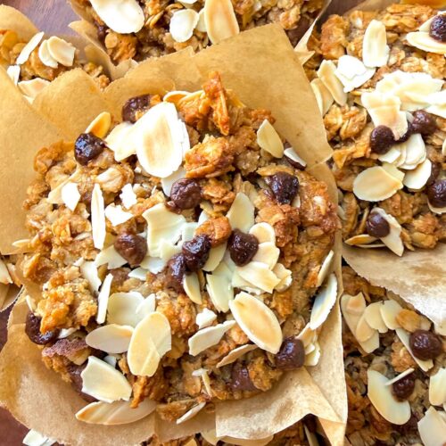 Close-up of gluten-free banana bread crumble muffins with golden oat almond crumble, toasted sliced almonds, and sugar-free chocolate chips. These soft, moist, and delicious banana muffins are dairy-free, refined sugar-free, naturally sweetened, full of cozy banana bread flavour, and perfect for a healthy homemade snack or breakfast.