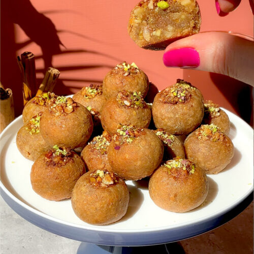 Healthy Baklava Bites served on a cake stand with one bite cut open to show the soft, moist, nutty centre. These gluten-free, grain-free, dairy-free, refined sugar-free, paleo baklava bites are crisp outside, tender inside, sweetened with honey, made with almonds, walnuts and pistachios, and perfect for a delicious healthy dessert or afternoon tea treat.