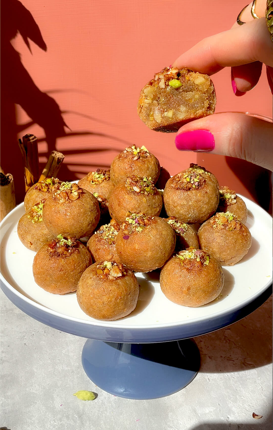 Healthy Baklava Bites served on a cake stand with one bite cut open to show the soft, moist, nutty centre. These gluten-free, grain-free, dairy-free, refined sugar-free, paleo baklava bites are crisp outside, tender inside, sweetened with honey, made with almonds, walnuts and pistachios, and perfect for a delicious healthy dessert or afternoon tea treat.