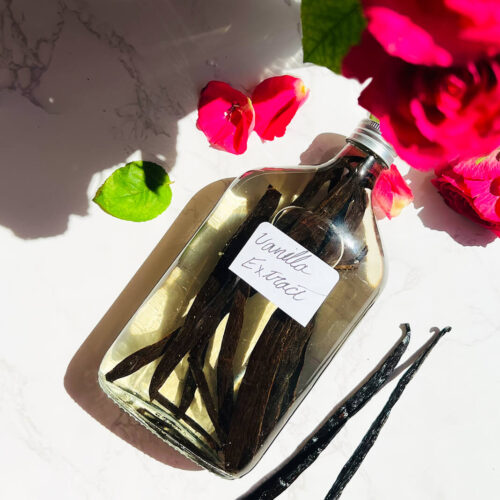 How to make your own Vanilla Extract, with only 2 simple ingredients. Madagascar vanilla beans beside a bottle of homemade vanilla extract, showing the real vanilla pods used to make pure DIY vanilla extract at home.