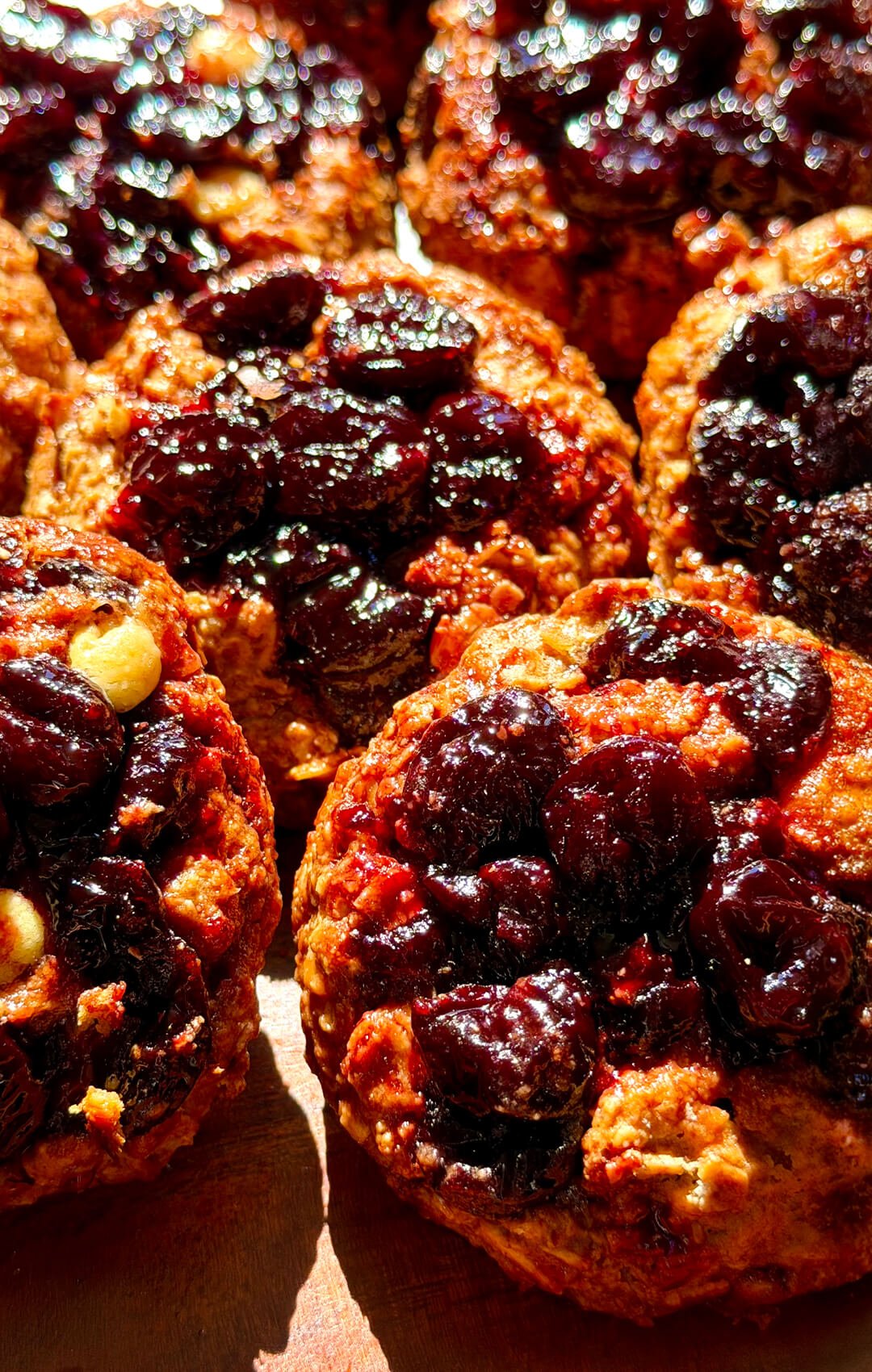 Batch of healthy peanut butter sour cherry oatmeal cookies with golden caramelized edges, glossy homemade cherry filling and sugar-free white chocolate, made with rolled oats and almond flour and perfect as a wholesome breakfast or snack cookie.
