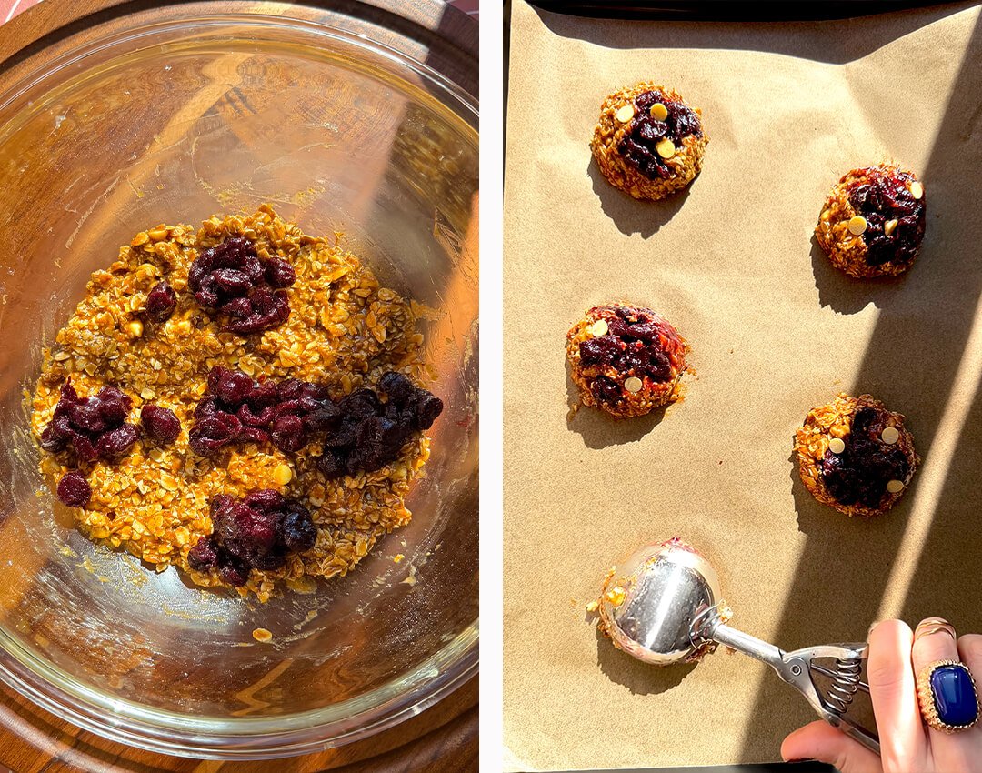 Thick homemade sour cherry filling spooned in separate pockets over peanut butter oatmeal cookie dough before scooping large cookies onto a lined baking tray, helping keep the cookies thick and chewy.