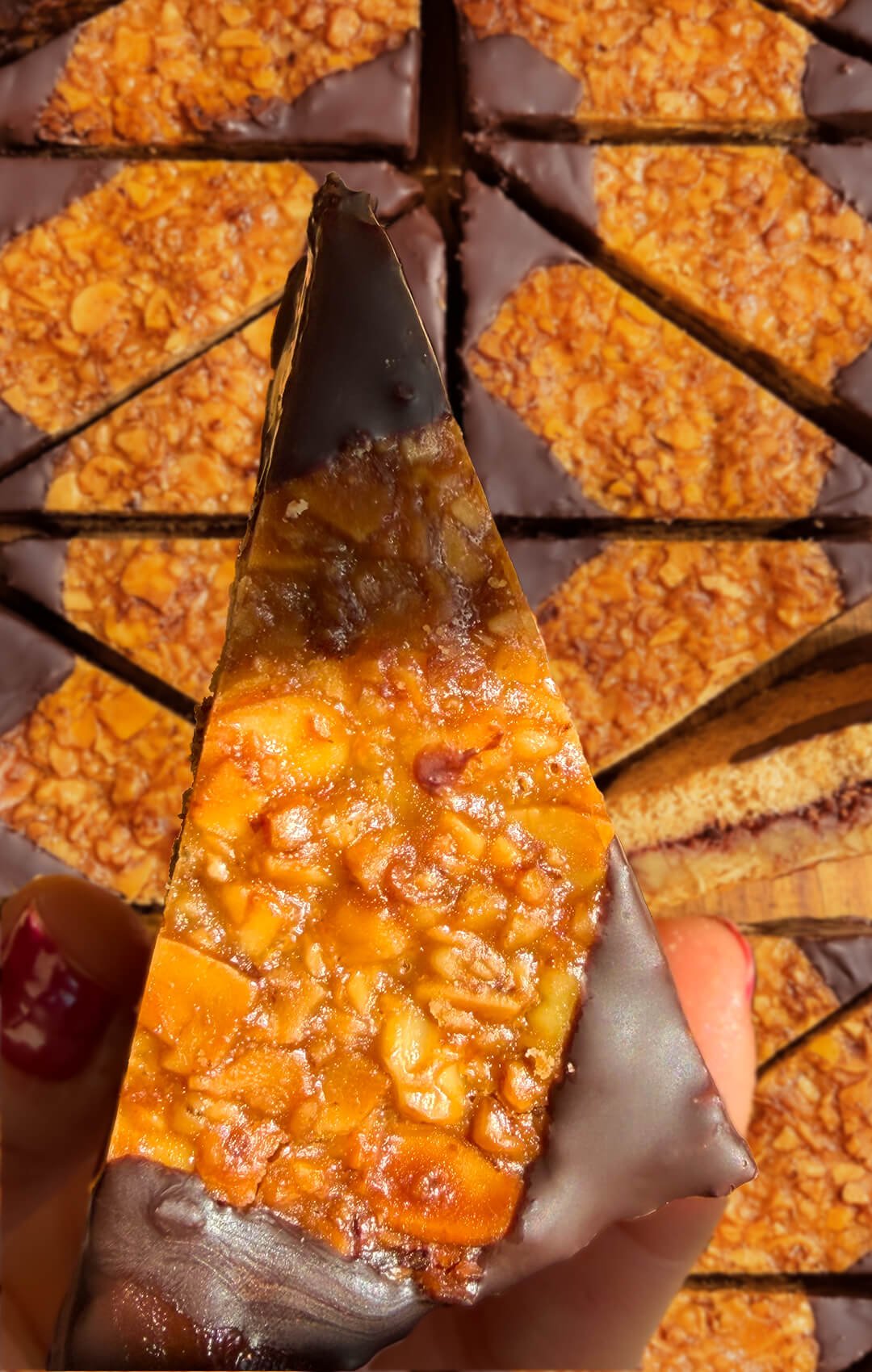 German Nussecken inspired cookie with a golden crunchy almond walnut topping, raspberry jam layer and three dark chocolate dipped corners.