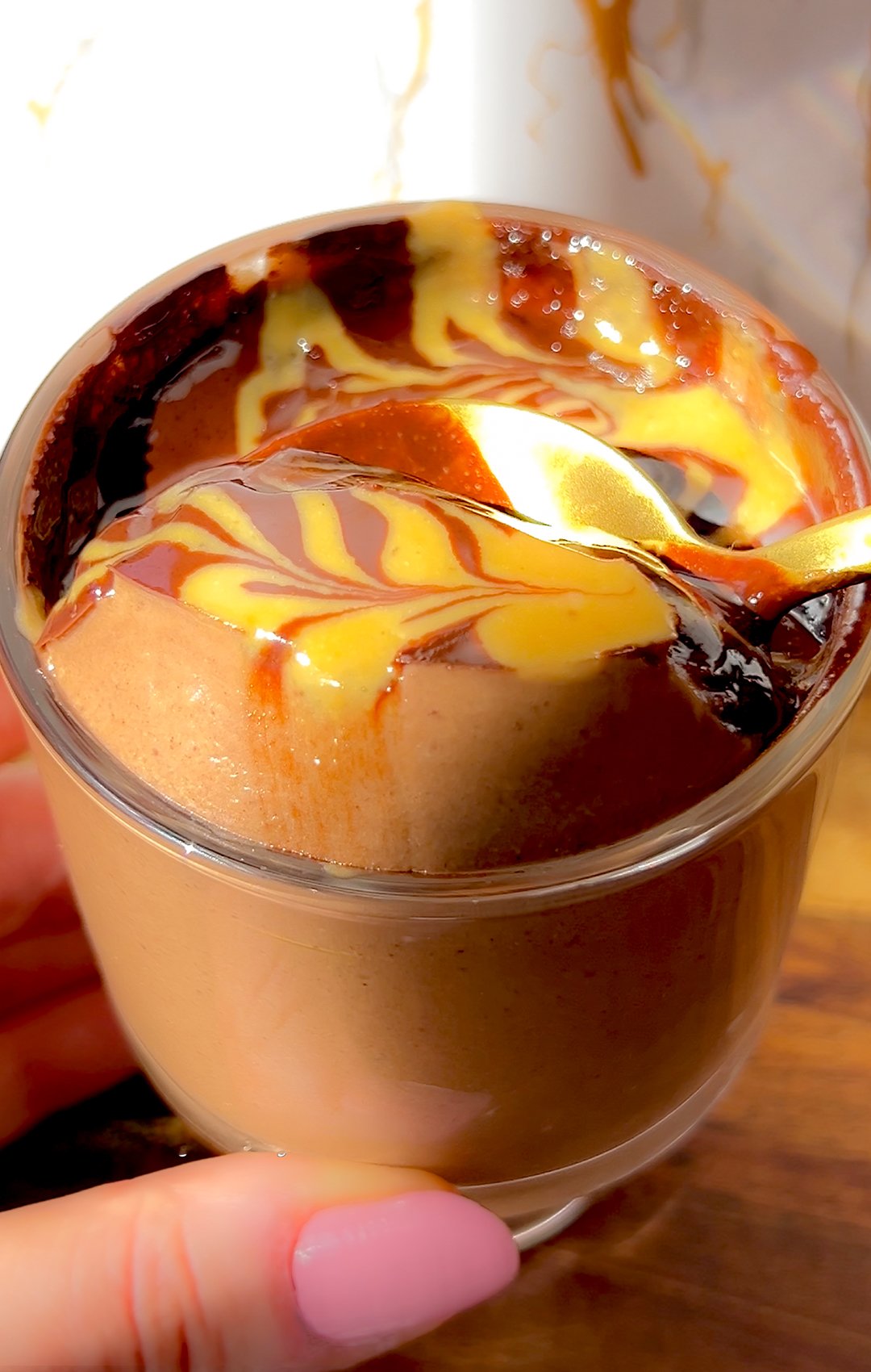 Thick and creamy high-protein chocolate Greek yogurt pudding topped with a glossy chocolate and peanut butter swirl.