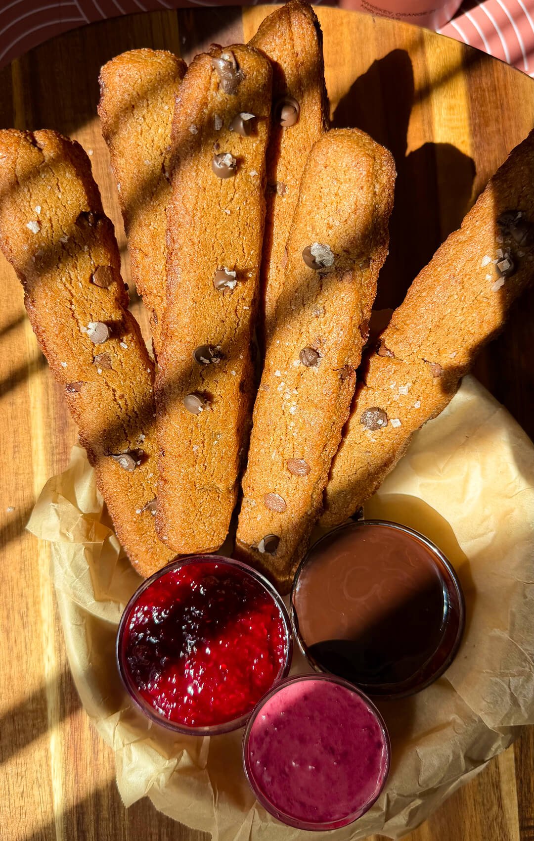 Golden homemade chocolate chip cookie fries made with almond flour and brown butter, served with homemade raspberry jam, chocolate sauce and a raspberry cream dip.